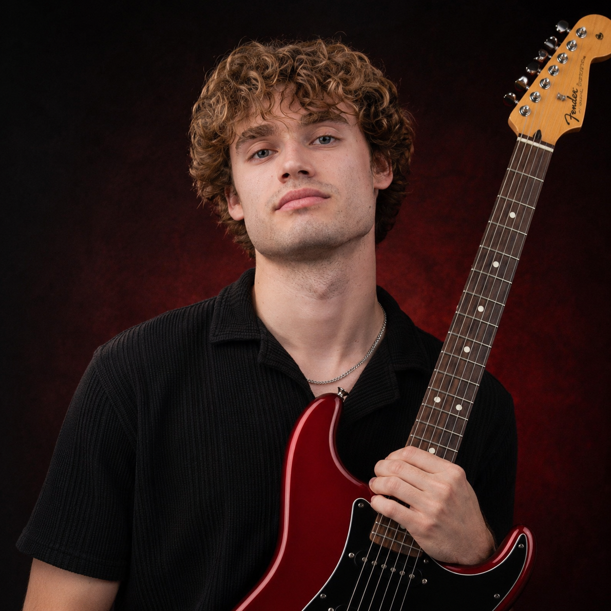 Christian Little holding his red electric guitar