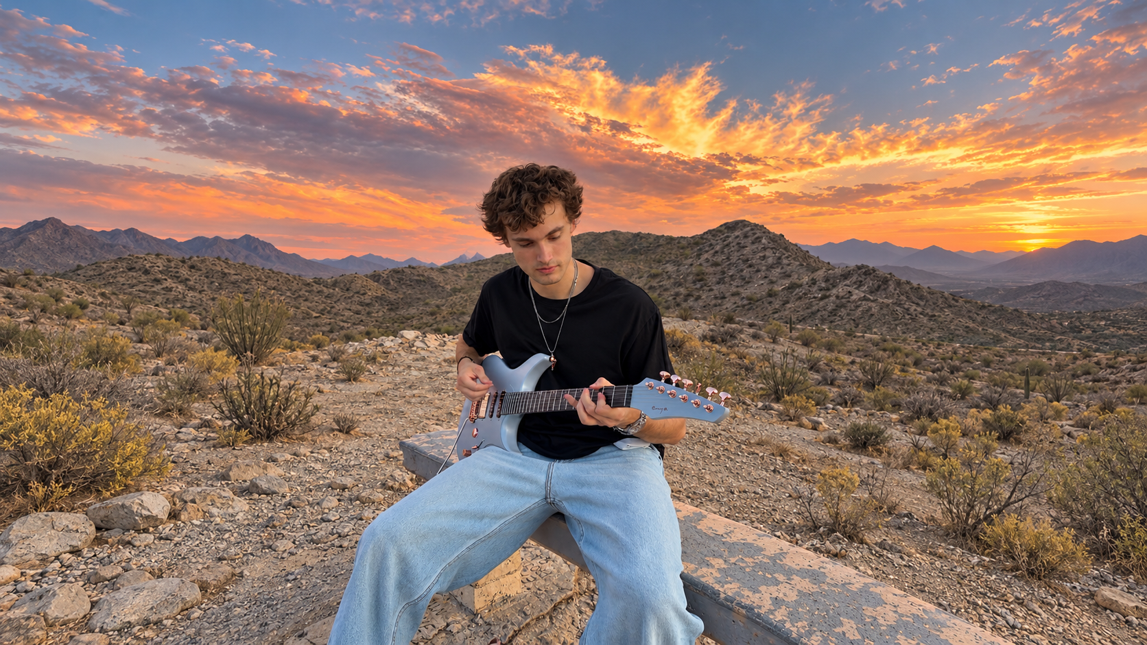 Christian playing guitar in the desert at sunset